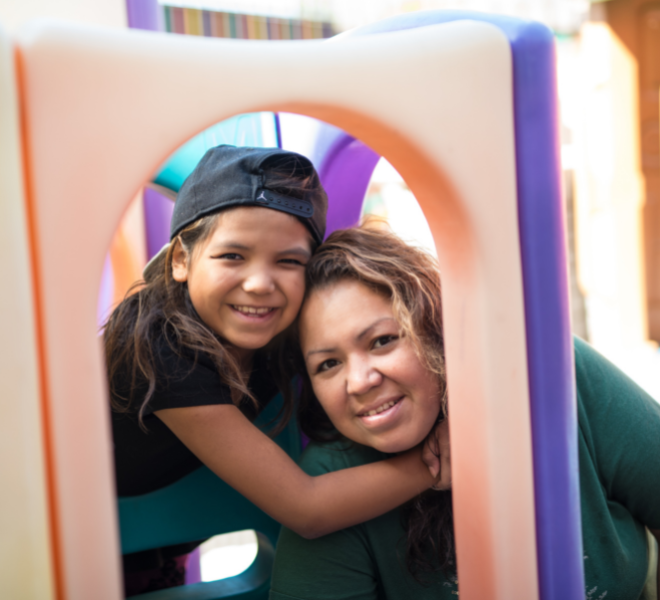 A mother and child hugging in playset